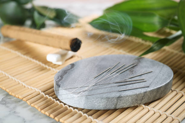 istock Grey stone coaster with acupuncture needles on bamboo mat 1452867251