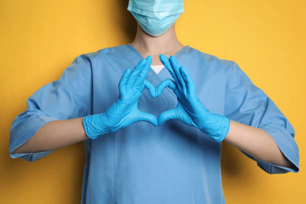 istock Doctor making heart with hands on yellow background, closeup 1452867446
