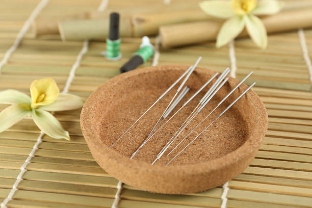 Cork plate with acupuncture needles on bamboo mat Cork plate with acupuncture needles on bamboo mat acupuncture mat stock pictures, royalty-free photos & images