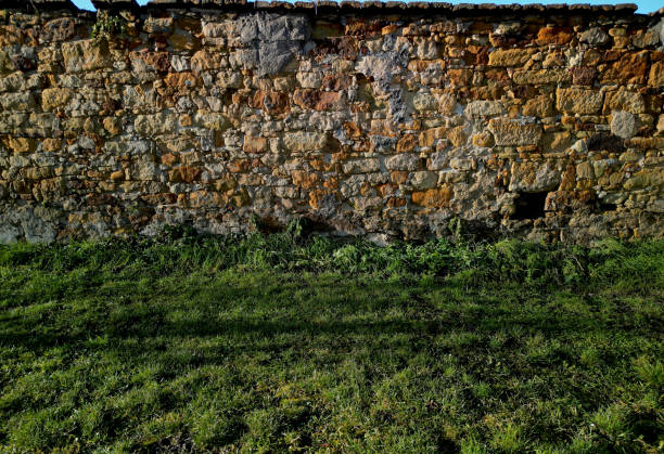 istock old stone wall and retaining wall with the help of cement and concrete solid staircase with cubes black metal railing and flower bed by the sidewalk in the spring sun 1452867554