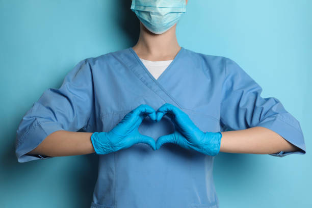 istock Doctor making heart with hands on light blue background, closeup 1452867619