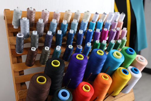 Set of colorful threads on stand in dressmaking workshop