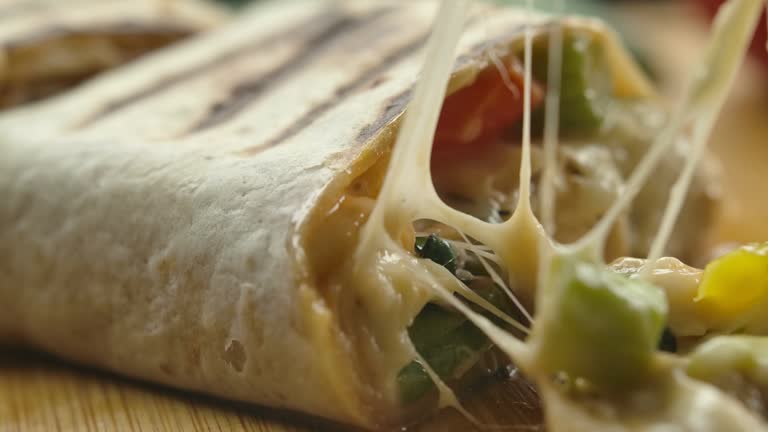 Super close-up of mexican burrito with melted cheese and Juicy pieces of meat