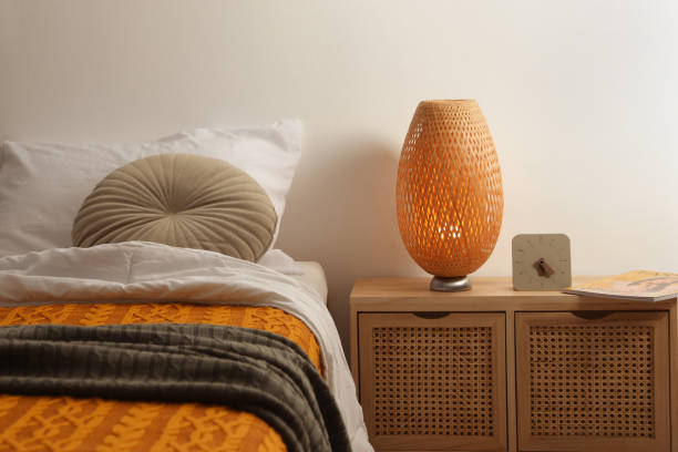 istock Stylish lamp, magazine and alarm clock on bedside table indoors. Bedroom interior elements 1452868954