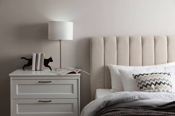 istock Stylish lamp, books and magazine on bedside table indoors. Bedroom interior elements 1452868955