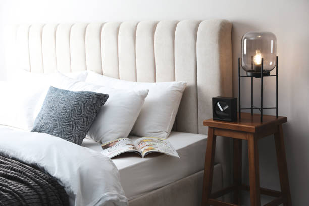 istock Stylish lamp and alarm clock on bedside table indoors. Bedroom interior elements 1452868998