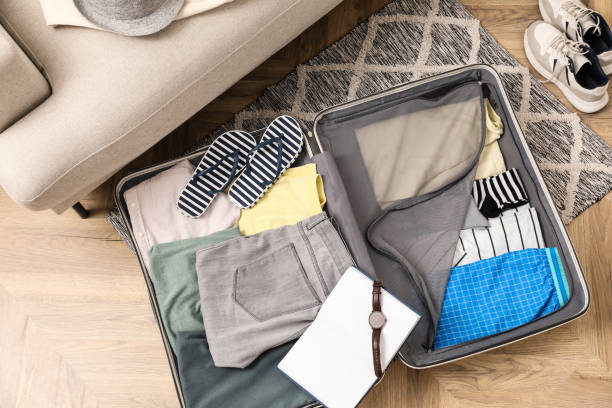 istock Open suitcase with different men clothes and accessories on floor, top view 1452870653
