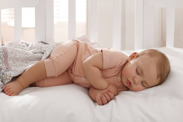 Cute little baby sleeping in soft crib at home stock photo