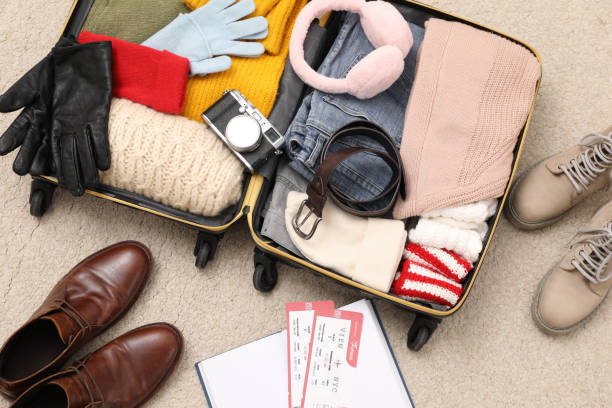 istock Open suitcase with warm clothes, accessories and shoes on floor, flat lay 1452870705