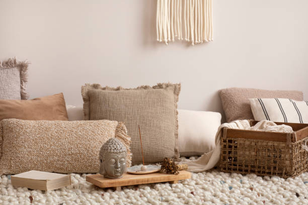 istock Creative composition of meditation living room interior with beige carpet, pillows, macrame and personal accessories. Home decor. Template. 1452870788