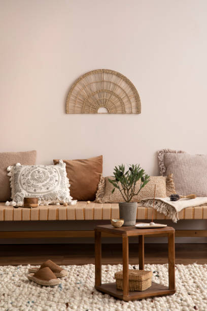 istock Creative composition of meditation living room interior with mock up poster frame, beige carpet, colorful pillow, coffee table and personal accessories. Home decor. Template. 1452870800