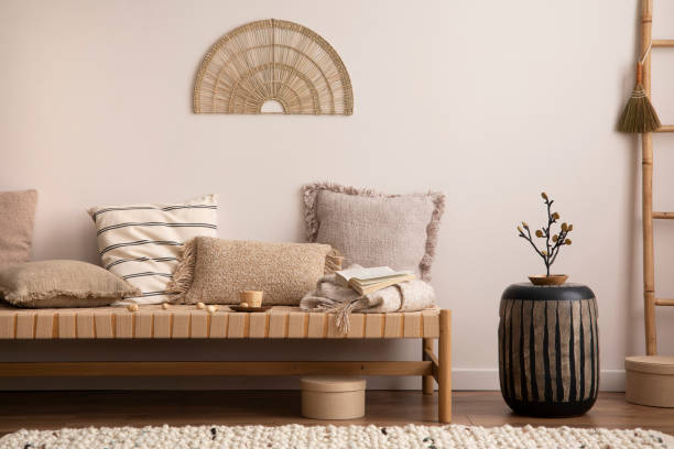 istock Creative composition of meditation living room interior with mock up poster frame, beige carpet, colorful pillow, coffee table and personal accessories. Home decor. Template. 1452870815