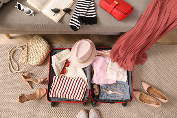 istock Open suitcase with different women clothes and accessories on floor, top view 1452871447