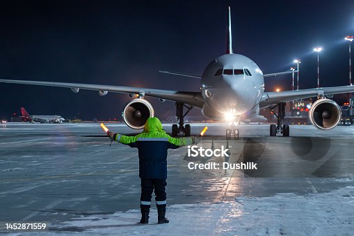 istock Airliner marshalling at the aiport apron at winter night 1452871559