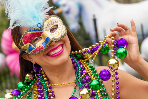 A young latin tourist female, wearing mask, costumes and necklaces celebrating Mardi Gras through the streets in New Orleans. A young latin tourist female, wearing mask, costumes and necklaces celebrating Mardi Gras through the streets in New Orleans. This is the most important celebration for the city. new orleans mardi gras stock pictures, royalty-free photos & images