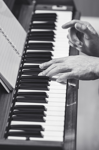 black and white male musician hands playing classical piano. music concept