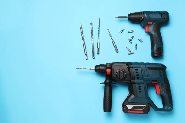 istock Modern electric power drill and different bits on light blue background, flat lay. Space for text 1452874786