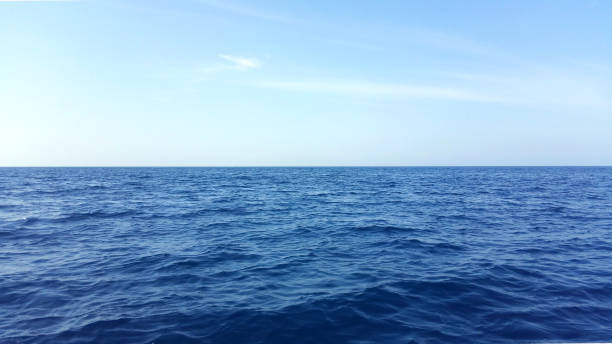 istock Seascape horizon line in open sea water wtih small waves and blue sky background image 1452875989