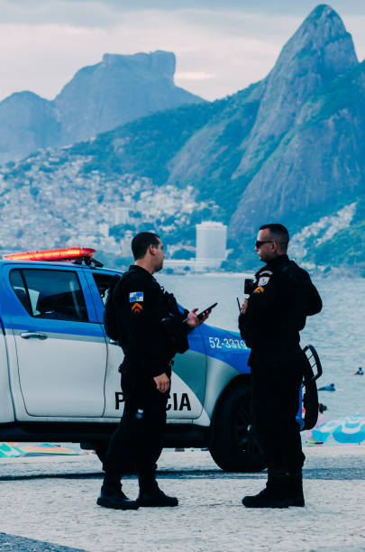 Police watch over tourists in Arpoador, Rio de Janeiro, Brazil. Rio is a popular tourist city but also experiences high levels of crime stock photo