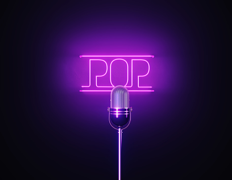 Purple neon light writes pop above a silver colored microphone over black background. Horizontal composition with copy space.