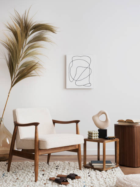 istock Creative composition a living room interior with mock up poster, beige armchair, coffee table, lamp, vase with dried flowers and personal accessories. Home decor. Template. 1452877694