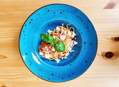 Spaghetti with tomato sauce and aubergines and parmesan cheese and basil herb