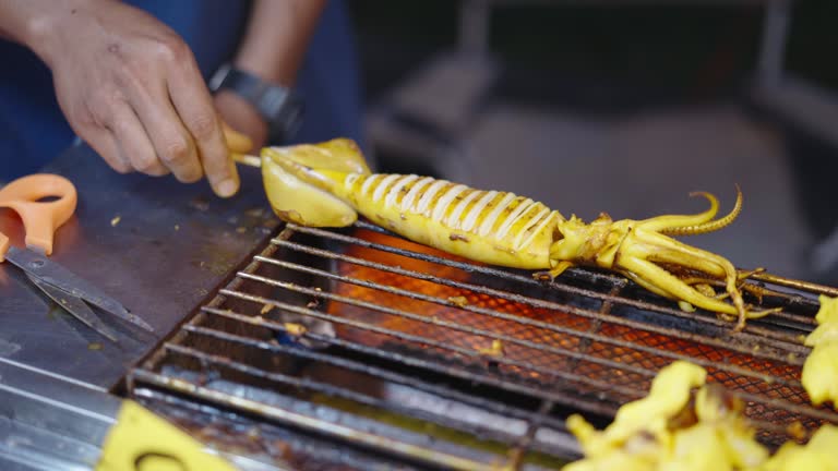 Large squid skewer being cooked on hot grill