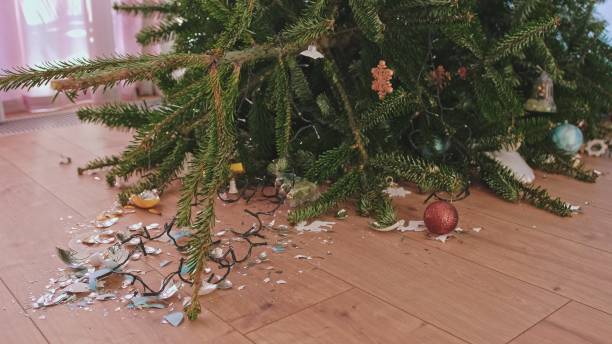 istock Fallen Over Christmas Tree with Broken Glass Baubles Decorations Shattered on Floor 1452880519