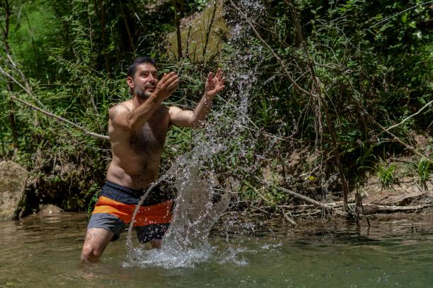 istock man in the river splashing water with his hands 1452880886