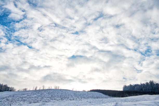 scène hivernale enneigée sur ciel nuageux. paysage nuageux cumuliforme sur paysage hivernal - cumuliform photos et images de collection