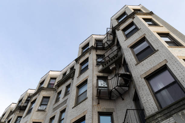 istock Undulating surface of a light brick apartment building seen from an extreme upward angle, metal grate balconies 1452886622
