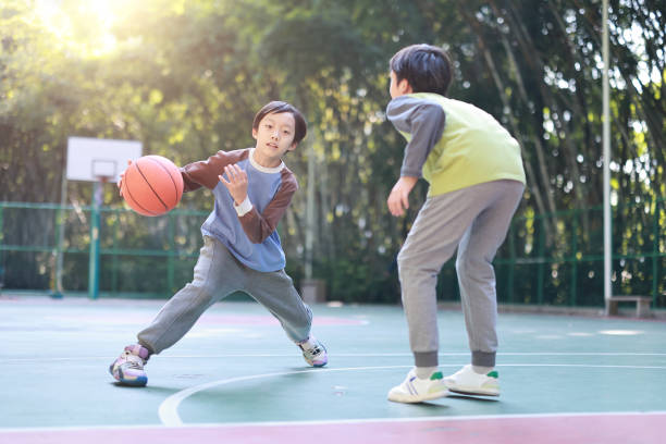 istock Two boys playing basketball outside 1452887303