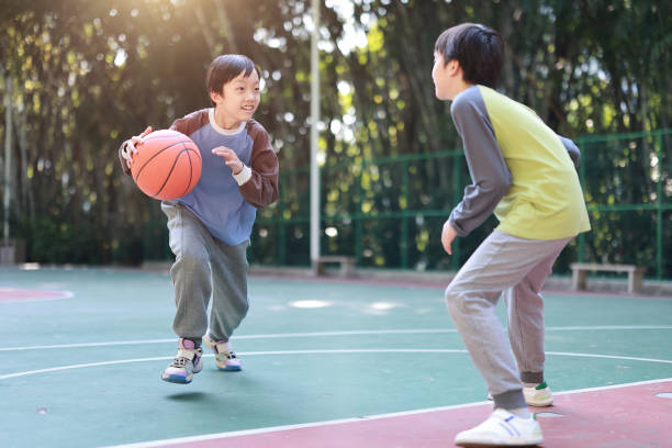 istock Two boys playing basketball outside 1452887320