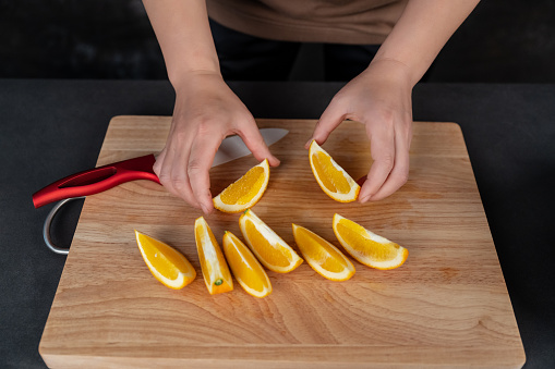 A housewife is cutting oranges on the workbench