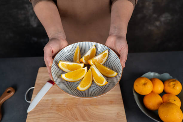 A housewife is cutting oranges on the workbench