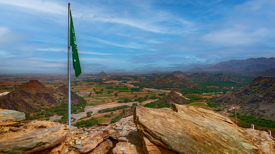 A saudi flag on the top of an old ottoman fort in the mountains close to Jazan in Saudi Arabia