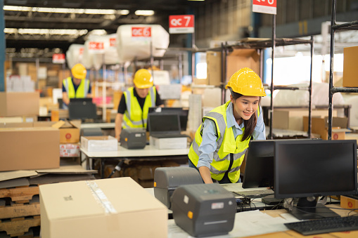 Teamwork of Asian workers working in large warehouse store industry.Rack of stock storage. Interior of cargo in ecommerce and logistic concept. Depot. People lifestyle. Shipment service for container