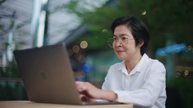 Professional businesswoman working with laptop outside office.