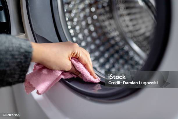 Female Hand Cleaning Washing Machine From Dirt With Pink Cloth Wiping Rubber Seal On Washing Machine Drum Stock Photo - Download Image Now