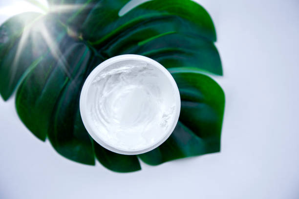 istock Cosmetic product anti-age moisturizing cream on green leaf with sun light 1452899591