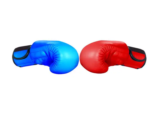 Red and blue boxing gloves hitting each other isolated on white background.