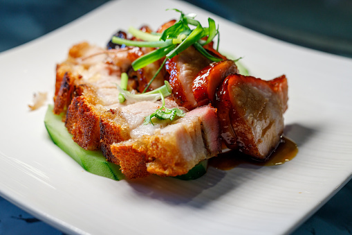 Homemade grilled pork steak with chimichurri verde sauce on cutting board on dark background