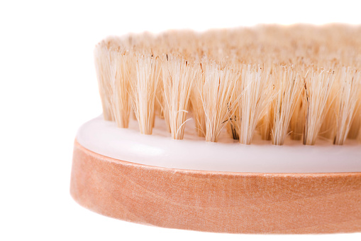 Wooden brush for dry massage with natural bristles isolated on white background.