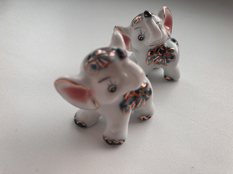 Elephant porcelain statue on white background. Family collection - two kids-elephants and their mother
