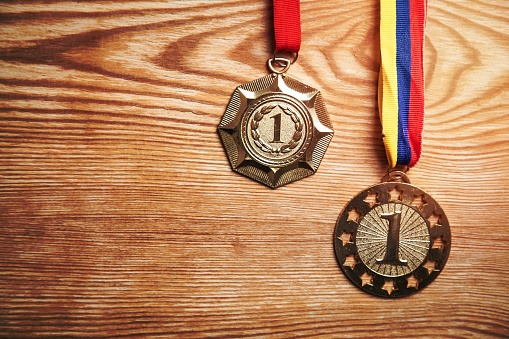 Medals awards for winner on wood background.