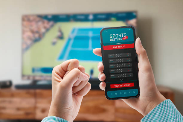 Live in-play betting app Live in-play betting app on smartphone display, a woman is betting at home and winning, POV shot betting stock pictures, royalty-free photos & images