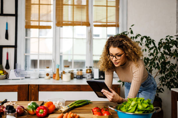 istock Young woman searching online help for cooking 1452910332