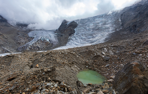 Ried Glacier with a glacial lake in a debris field with rocks in Valais near Gasenried and Grachen.
