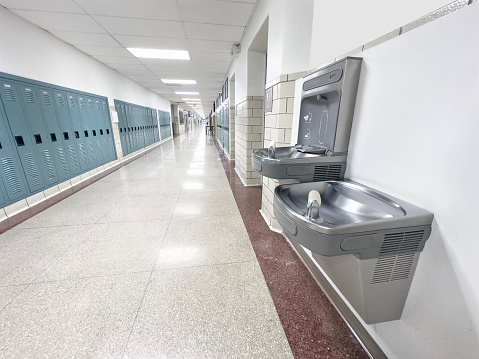 Water fountain in corridor of a public school with lockers