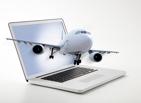 Passenger plane coming out of laptop screen symbolizing online ticketing
